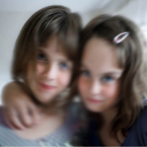 Blurry image of two young girls posing for the camera